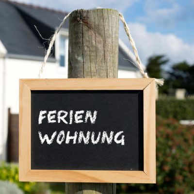 Ein Haus und eine Kreidetafel mit dem Wort Ferienhaus