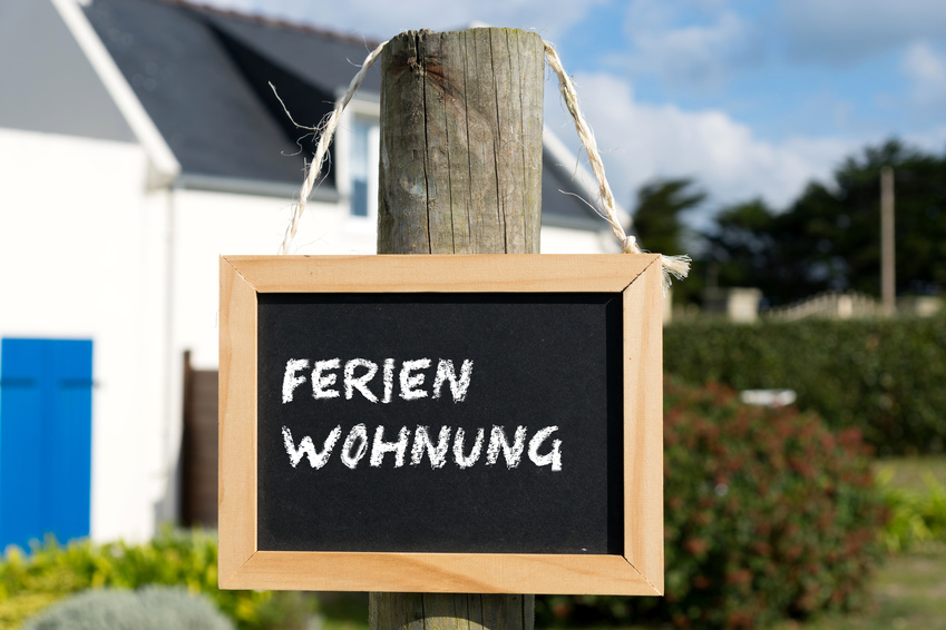 Ein Haus und eine Kreidetafel mit dem Wort Ferienhaus